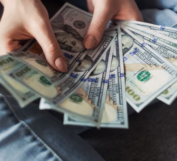 Hands holding US dollar bills